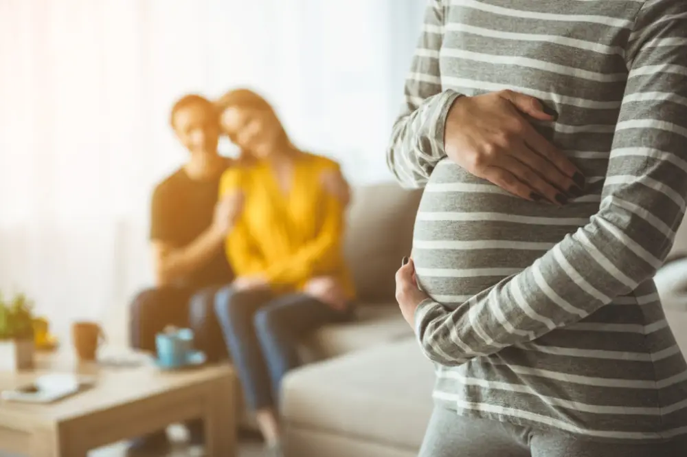 Pregnant woman with couple in background representing surrogacy contracts and family formation legal support.